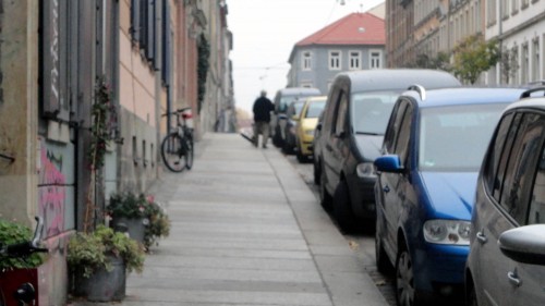 Mit Schwung wird die Straße gekehrt.