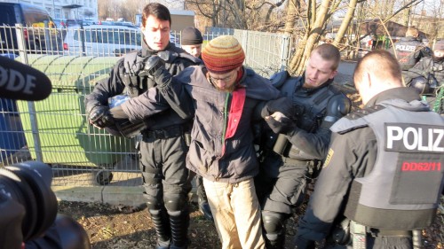 Polizisten führen einen Blockierer ab.