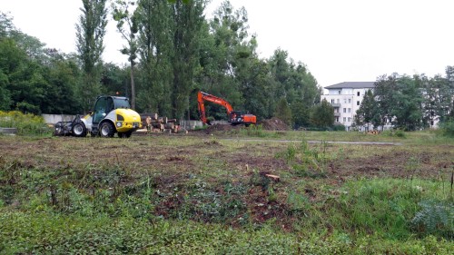 Mit schwerem Gerät wird die Fläche neben dem Parkplatz von Bäumen und Sträuchern befreit.