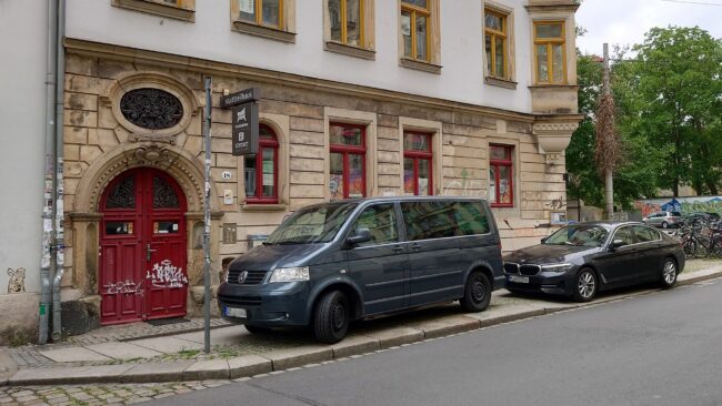 Zwei Einsatzfahrzeuge parken vor dem Stadtteilhaus auf dem Gehweg.