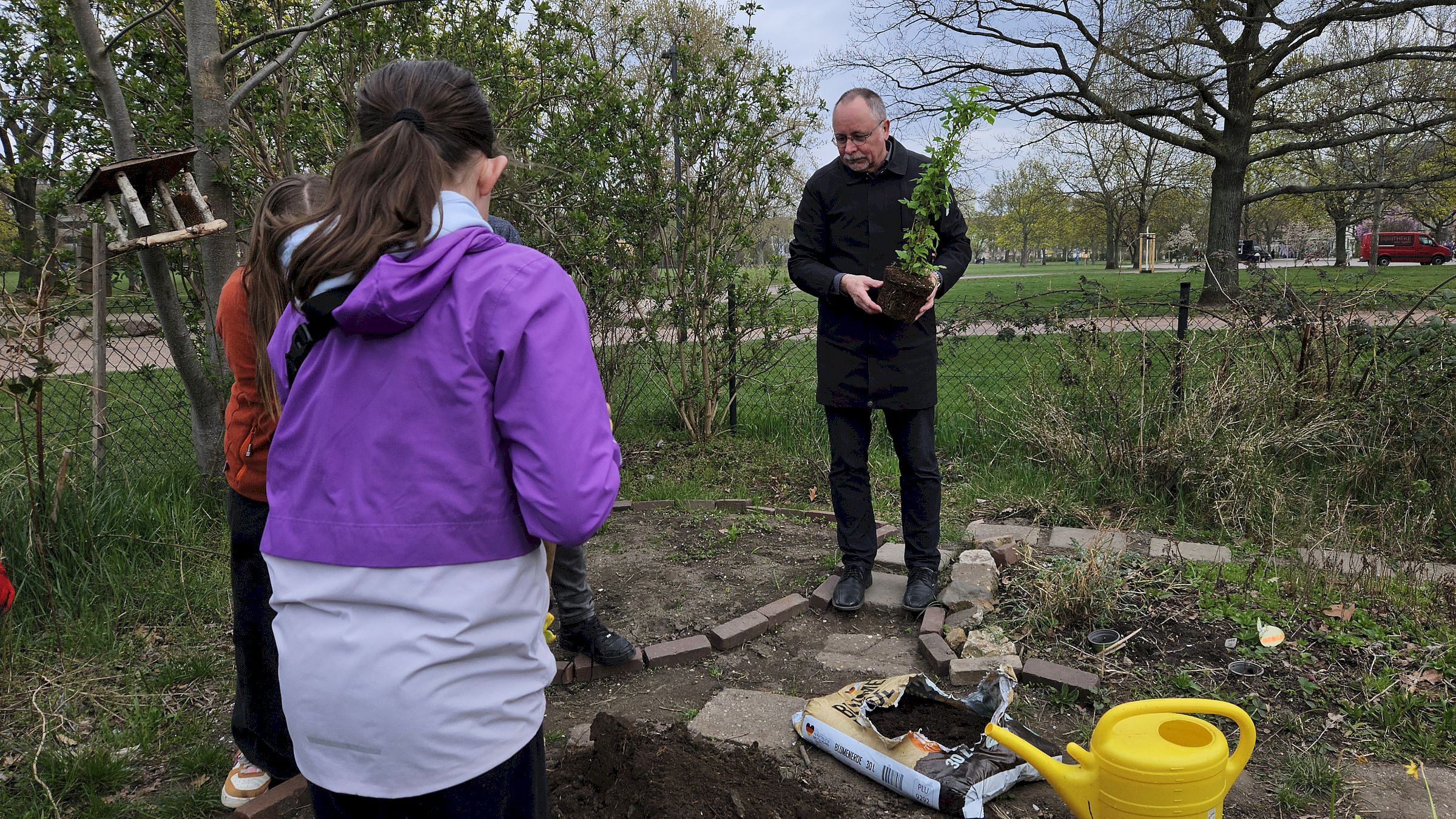 Stadtbezirksamtsleiter André Barth zeigte seinen grünen Daumen und versenkte eigenhändig eine Pflanze im Gemeinschaftsgarten. Foto: Anton Launer