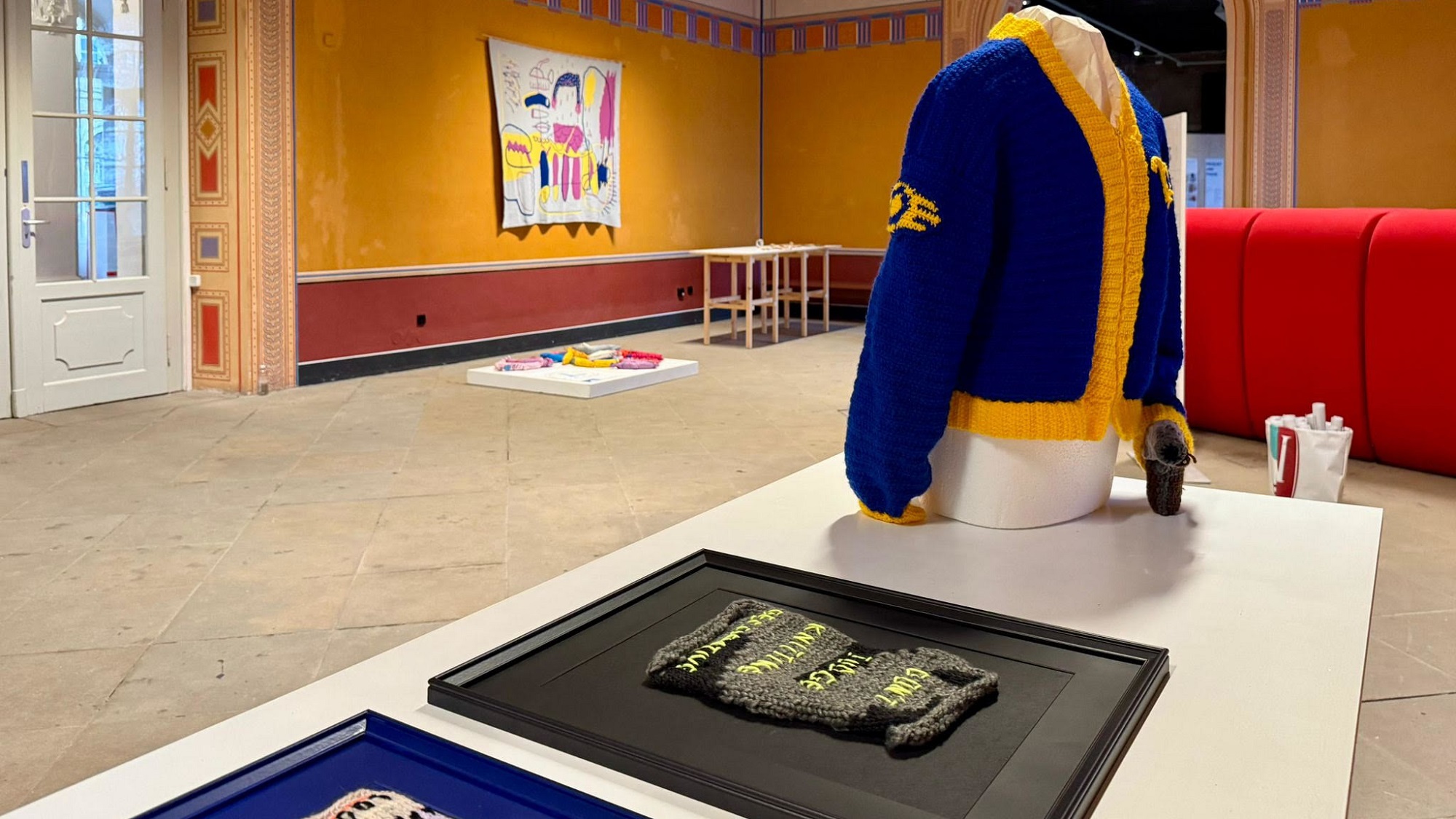 Die Wanddecke von Bettina Kletzsch im Hintergrund gab den Anstoß zur Strick-Ausstellung. Katja Gärtner und Crochet of Death zeigen mit den gerahmten Textilien und der Jacke, wie vielfältig eine Ausstellung zu dem Thema werden kann.